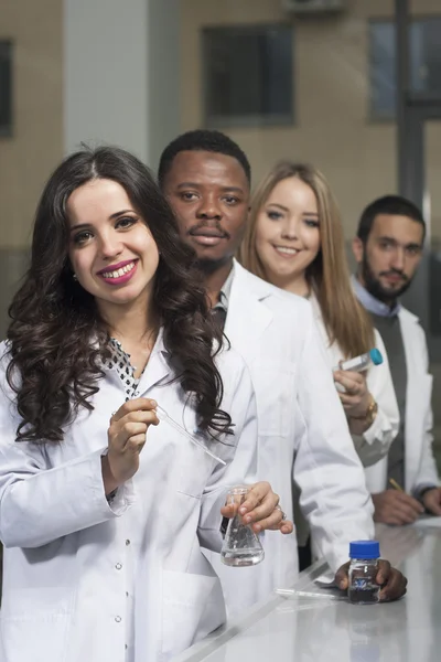 Grup genç tıbbi işçilerin are çalışma laboratuarda laboratuar tekniği