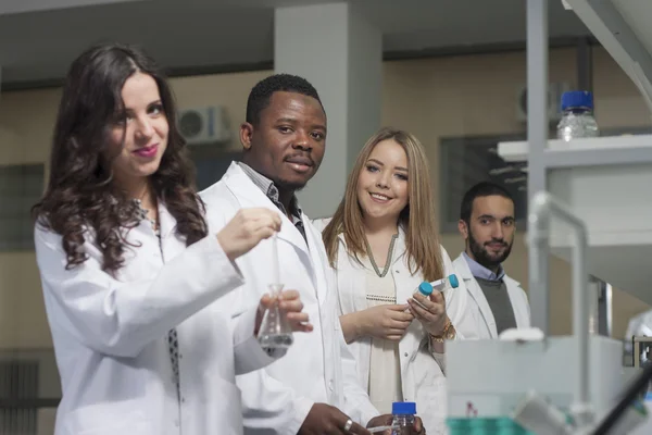 Grup genç tıbbi işçilerin are çalışma laboratuarda laboratuar tekniği