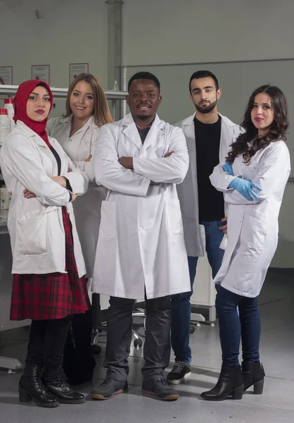 Grup genç tıbbi işçilerin are çalışma laboratuarda laboratuar tekniği