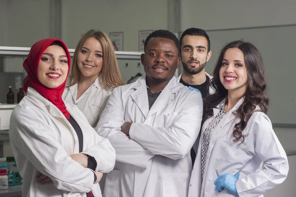 Grup genç tıbbi işçilerin are çalışma laboratuarda laboratuar tekniği