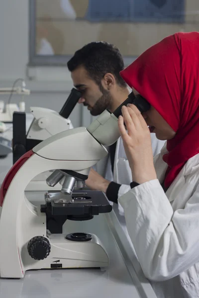 Grup genç tıbbi işçilerin laborant laboratuarda çalışıyoruz