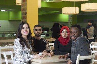 Grup karışık ırk öğrenci kantinde asılı