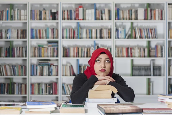 Retrato de belo jovem estudante na biblioteca — Fotografia de Stock