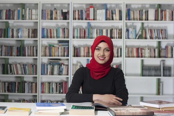 Retrato de belo jovem estudante na biblioteca — Fotografia de Stock