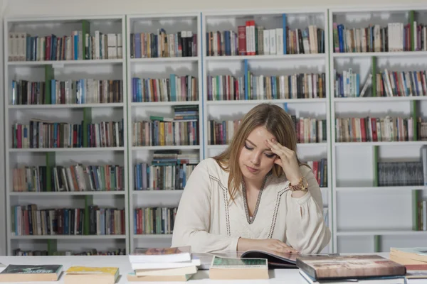 Porträt einer hübschen jungen Studentin in der Bibliothek — Stockfoto