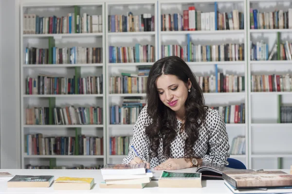 Porträt einer hübschen jungen Studentin in der Bibliothek — Stockfoto