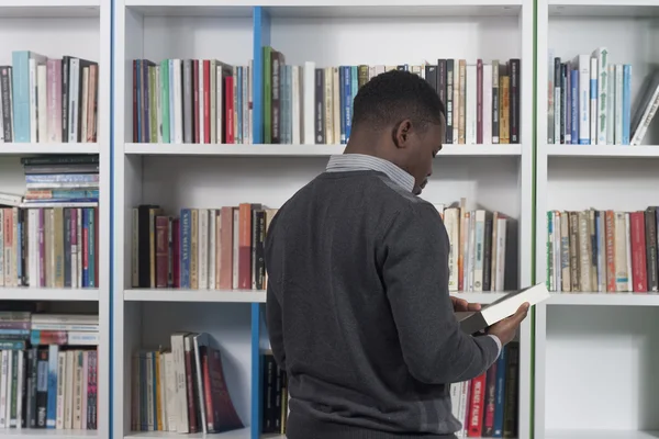 Estudantes em busca de livros na biblioteca — Fotografia de Stock