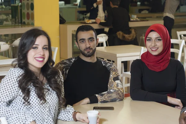 Há um grupo de estudantes mestiços na cantina. — Fotografia de Stock