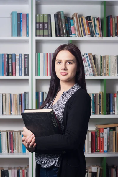 Fiatal női hallgató a könyvtárban — Stock Fotó