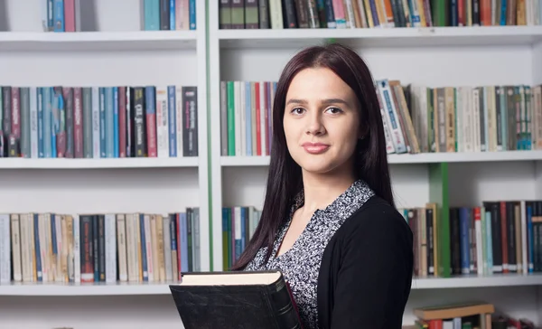 Fiatal női hallgató a könyvtárban — Stock Fotó
