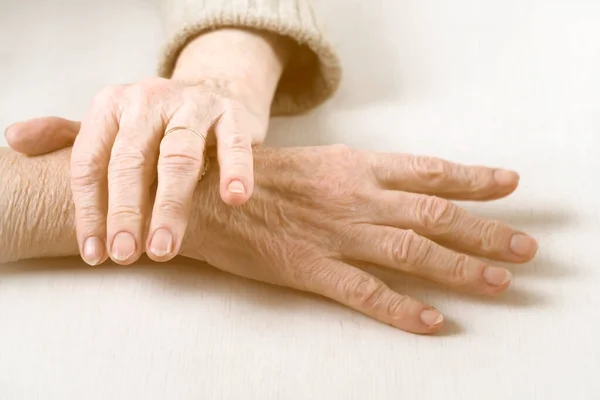 As mãos de uma mulher idosa bem tratada em uma camisola casual. — Fotografia de Stock