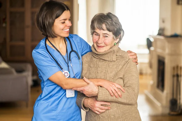 A young nurse shows care and professionalism in relation to an elderly woman.