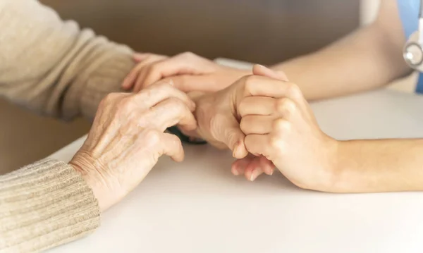 A young nurse shows care and professionalism in relation to an elderly woman — Stock Photo, Image