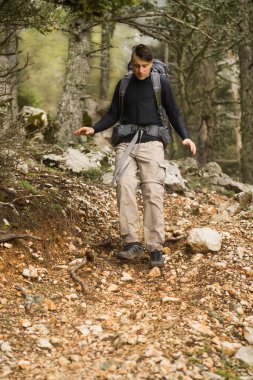 Genç bir adam, bir gezgin. Sırt çantası ve turistik ekipmanları var.