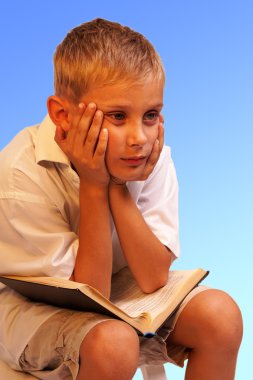 Boy with books for an education portrait - isolated on blue background