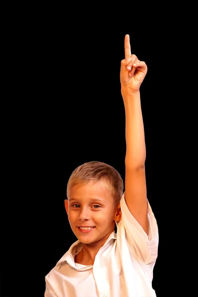 Cheerful little boy pointing up isolated on black background — 스톡 사진