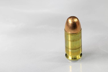 Close up of bullet 11 mm or .45 acp FMJ (Full Metal Jacket ) ready for use, isolate on white background reflection surface.