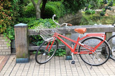 Bisikletler, Japonya 'da kaldırıma park etmiş popüler ulaşım tipi. Japonya 'da kaldırıma park edilmiş kırmızı bisikletler. 