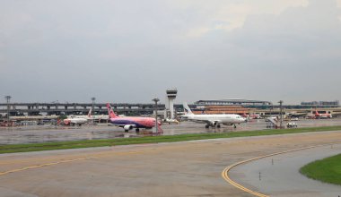 Don-MUEANG, BANGKOK - Mayıs 2018 Don-Mueang Uluslararası Havalimanı manzaralı, otoparktaki uçak parkı. Otobüs kapısından servis yolcuları. 
