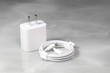 Beyaz arka planda beyaz şarj adaptörü ve beyaz USB kablosu beyaz arka planda izole edilmiş cihazlar için Yeni Şarj ve kablo konnektörü. Teknolojiyi cep telefonlarına yükleme kavramı. 