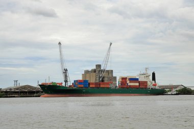 Uluslararası limanda vinçleri olan kargo gemisi veya Okyanus mavnası, CBD arka plan lojistiği ve ihracat sanayi konseptiyle.