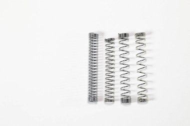 Farklı amaçlar için çeşitli metal yayları, birçok küçük krom yayları, beyaz arkaplanda izole edilmiş metal yayları