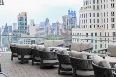Bir gökdelenin tepesinde rahat bir oturma alanı, çatı katı bar ve restoran alanında güzel şehir manzarası olan servis alanı.