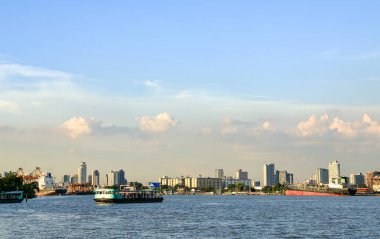Yeşil Feribot Chao Phraya 'dan Bangkok' a, Bangkok silueti manzaralı ve güzel mavi gökyüzü olan yolcuları taşıyor..