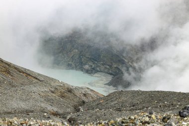 Patlayan yanardağın krater açılışının görüntüsü. Volkanik gaz fümerollü krater. Bulutlar ve gökyüzündeki buhar.
