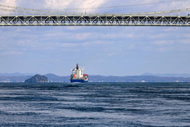 Büyük bir okyanus gemisi Kanmon köprüsünün altından geçerek Kitakyushu, Japonya 'daki denize doğru yola çıktı..