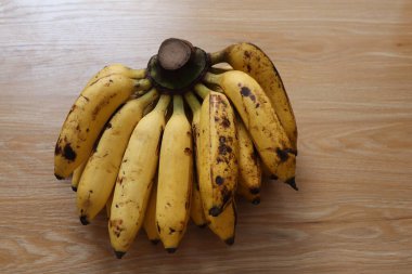 Tahta bir masada bir demet sarı muz.