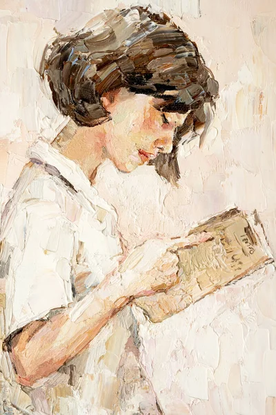 .A young girl reads an interesting book on a light warm background.