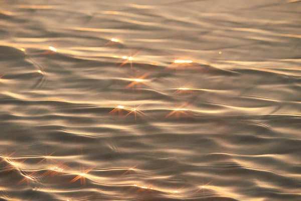 Texture of glitter water and soft waves. sparkling in water - background. sea water with sun glare and ripple. Powerful and peaceful nature concept.