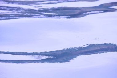 Parlak denize yansıyan güneş ışığının ayrıntıları. Suda maytap - arka plan. Güneş parlayan ve dalgalanan deniz suyu. Güçlü ve barışçıl doğa kavramı.