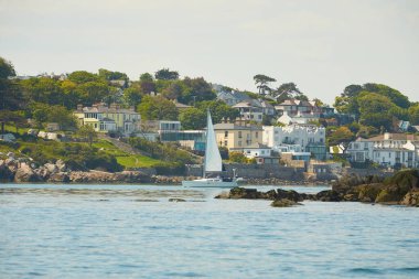 İrlanda Denizi 'ndeki kayalık adanın yanındaki denizde bir yat. İrlanda 'nın manzaraları.
