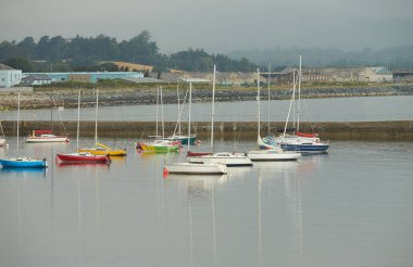 Limanda arka planda bulutlu gökyüzü olan tekneler.