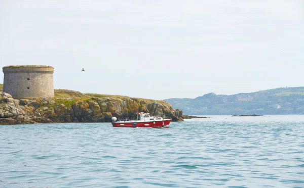 ラムベイ島を背景に海の中に赤い漁船 アイルランドの風景 — ストック写真