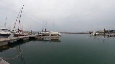 Günbatımında limanda bir tekne, lüks yatlar ve yelkenliler..