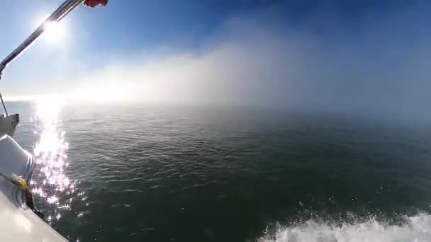 海に大きな隔離された霧の雲を運転しながら 移動船からの海の景色 輝く海に反射する太陽の光の詳細と霧の天気 自然の中で珍しいイベント — ストック動画