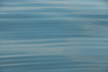 Parlak denize yansıyan güneş ışığının ayrıntıları. Suda maytap - arka plan. Güneş parlayan ve dalgalanan deniz suyu. Güçlü ve barışçıl doğa kavramı.