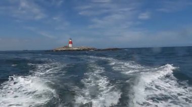 Issız adadaki eski Muglins Deniz feneri Mavi bulutlu gökyüzünün arkaplanı.