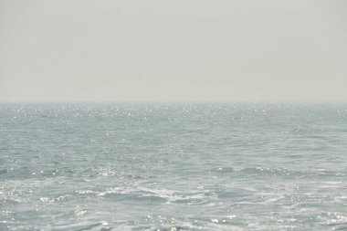 Parlak denize yansıyan güneş ışığının ayrıntıları. Suda maytap - arka plan. Güneş parlayan ve dalgalanan deniz suyu. Güçlü ve barışçıl doğa kavramı.