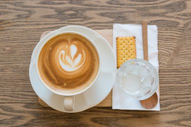 Sıcak latte vintage renk ahşap masa üzerinde