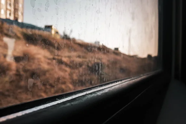 Hareket eden bir tren penceresinin köşesinde. Pencerelerde, estetik bir etki yaratan sıçrama izleri vardı.