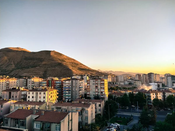Bu fotoğrafta, öğleden sonra dağın yanındaki şehir manzarasını görebilirsiniz..