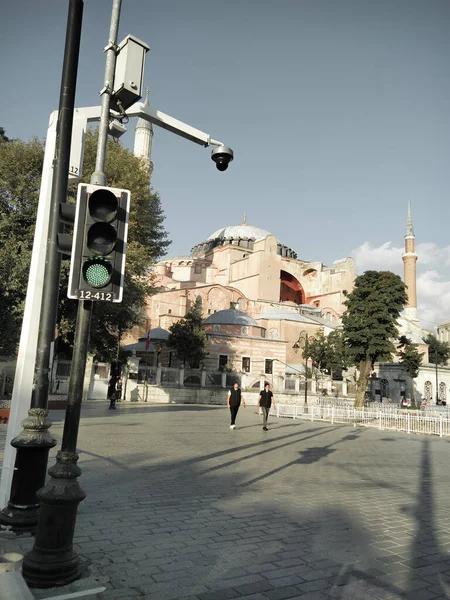 İstanbul, Türkiye - 26 Ağustos 2020: Bir çift gün içinde yeşil ışıkla Ayasofya Camii 'nin önünden geçiyor