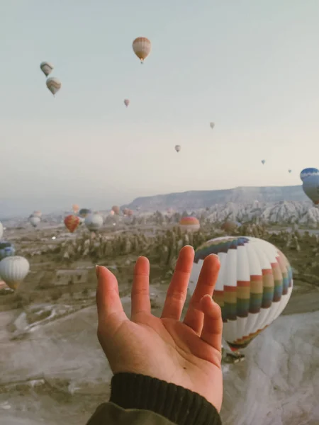 hands welcoming the sky among the balloons