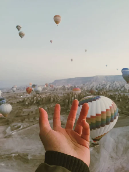 hands welcoming the sky among the balloons