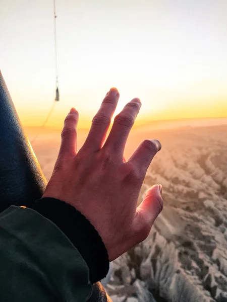 hands are reaching for the sky from the balloon, wave hands