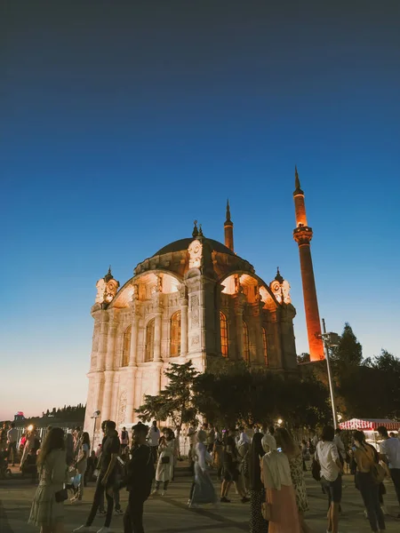 İstanbul, Türkiye - 20 Ağustos 2020: Cami camiinin, caminin manzarasının keyfini çıkarmak için caminin etrafında dolaşan insanların canlandırdığı gece Boğazı 'nın kenarındaki atmosfer